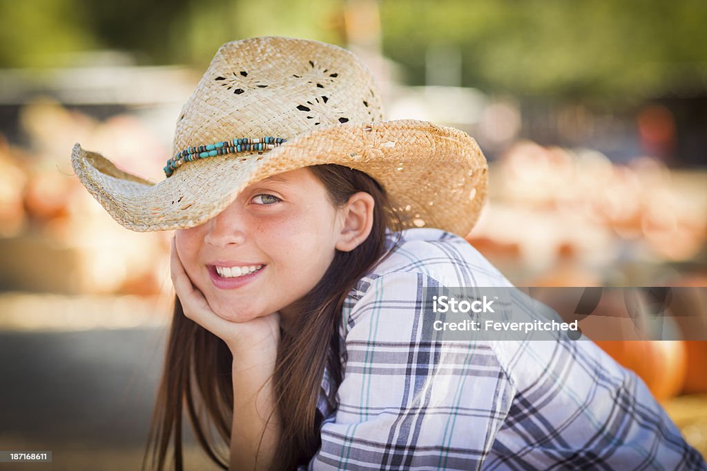 Preteen Girl Portrait at the Pumpkin Patch Preteen Girl Wearing Cowboy Hat Portrait at the Pumpkin Patch in a Rustic Setting. 12-13 Years Stock Photo