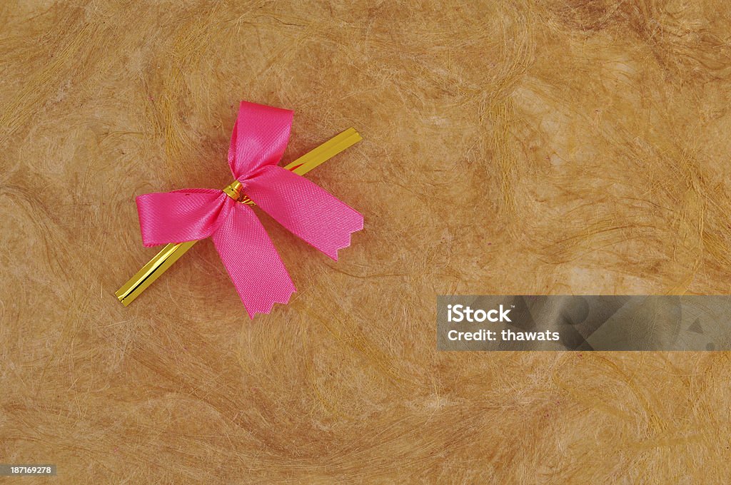 Pink satin ribbon Pink satin ribbon on Brown handmade mulberry paper Anniversary Stock Photo