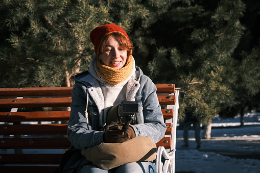 Cheerful mature woman is streaming in winter city park