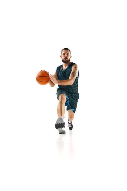 istock Professional basketball player honing skills with precision dribbling and making powerful slam dunk against white background. 1871696667