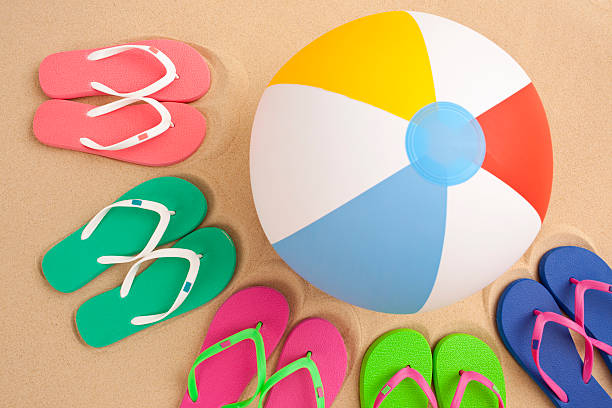 Five pair of flip flop and beach ball. stock photo