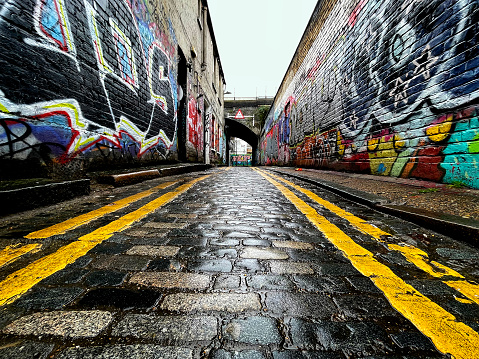 Road tunnel, with graffiti, under a railway line in Bethnal Green east London. March 2023