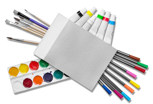 Colorful paints, blank sketchbook and brushes isolated on white background
