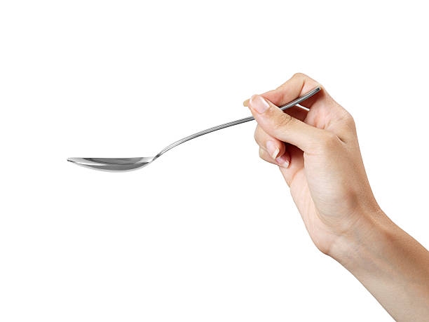 weibliche hand holding spoon - spoon stock-fotos und bilder