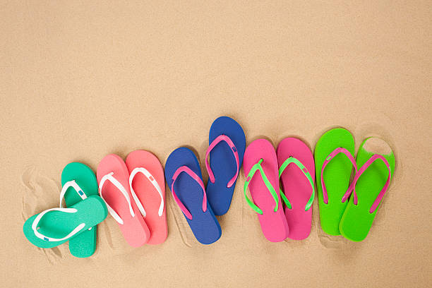 istock Five pair of flip flop isolated on sand. 187174451