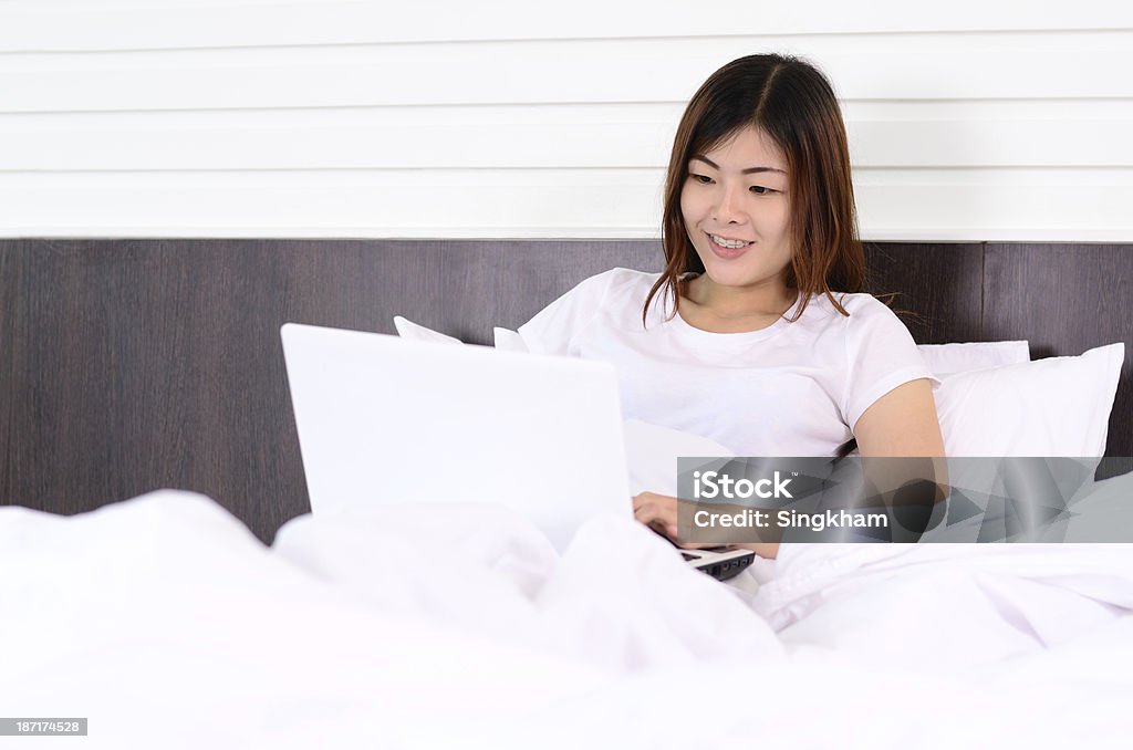 아시아계 10대 사용하여 랩탑 컴퓨터를 침대 - 로열티 프리 검은색 스톡 사진