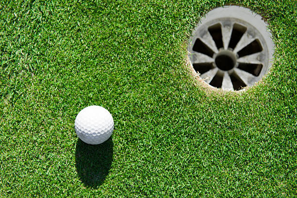 istock golf ball close to the hole 187174566
