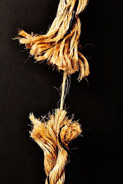 Any minute now. Breaking point! Frayed rope about to snap. This rope is frayed to its very last strand! Symbolic of stress, last minute urgency, and near disaster. Frayed stock pictures, royalty-free photos & images