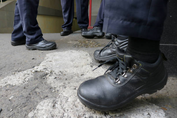 A group of workers wearing black leather safety shoes