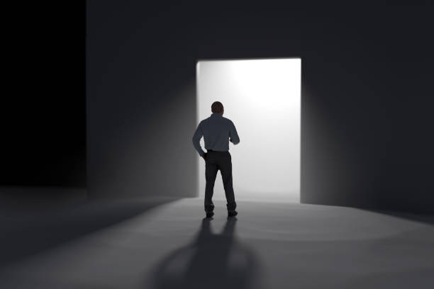 istock a man stands in front of the open doors towards the light 1871748279