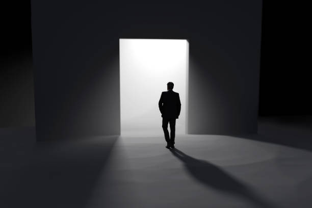 istock a man stands in front of the open doors towards the light 1871748280
