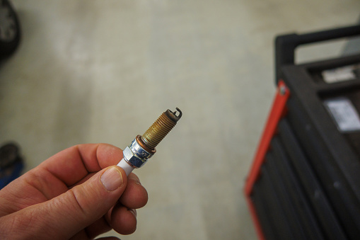 a removed spark plug is held in the hand