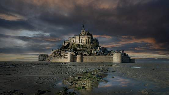 Mont Saint Michel, Manche, France, february 07 2022 : The famous Mont-Saint-Michel Abbey at low tide in Normandy with a dramatic sky