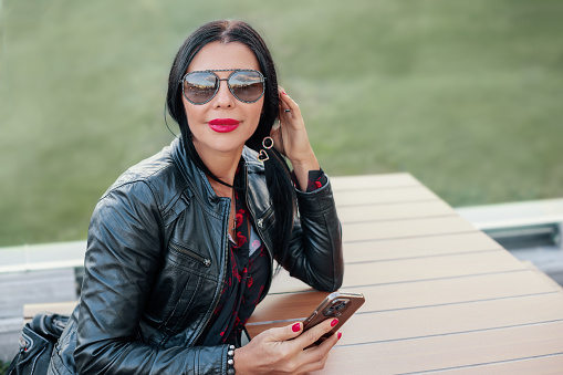 Woman sitting at a table and looking right to camera