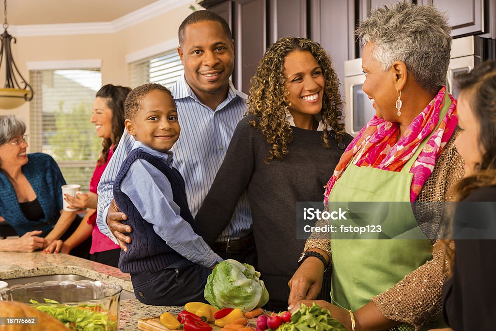 Relationships: Multi-generation family prepares dinner in kitchen. Family and friends gather for dinner at grandmother's house. Family Stock Photo