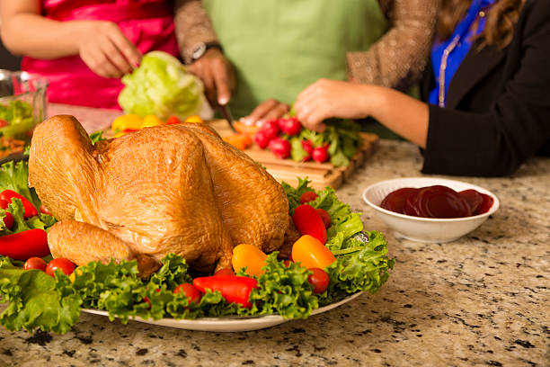 Family prepares dinner.  Turkey foreground.