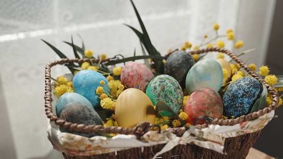 Easter treats on the table, self-made Decorated eggs in a basket.
