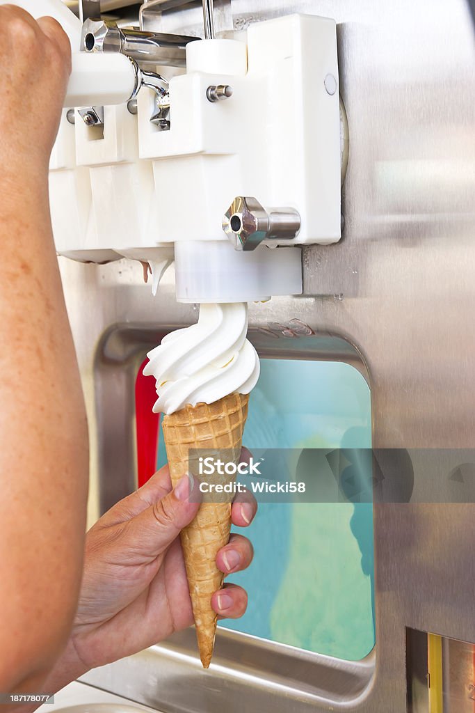 Soft serve ice cream being poured into waffle cone Tap of soft ice cream "Creemee" soft ice cream machine in action. Soft Serve Ice Cream Stock Photo