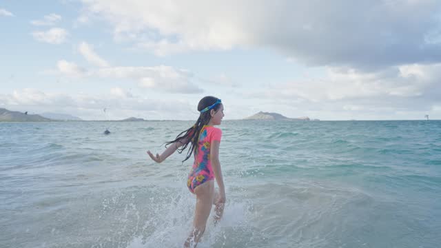 Excited girl running into the ocean