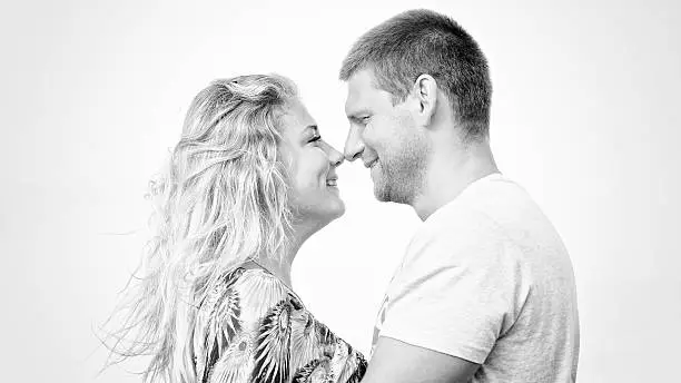 Photo of monotone shot of happy couple in love on the beach