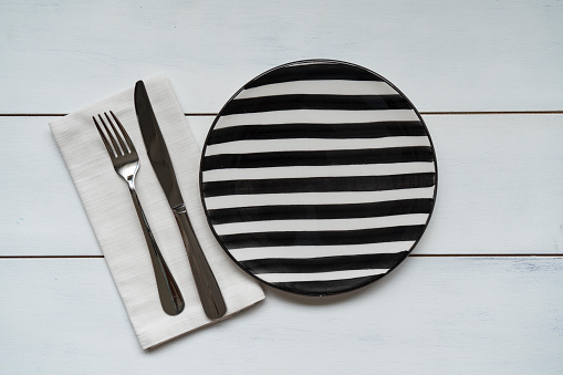 Empty plate and napkin on wooden background