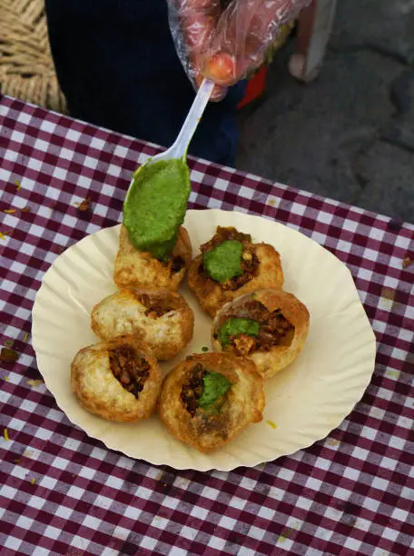 View of Indian street vendor making pani puri snack in outdoors