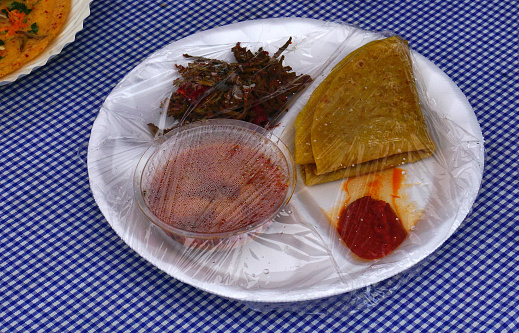 Close-up view of packaged Indian street food Chapathi,curry, pickle and fried vegetable curry