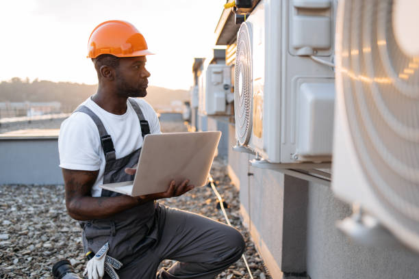 istock Carpenter using laptop while kneeling near air conditioner 1871802330