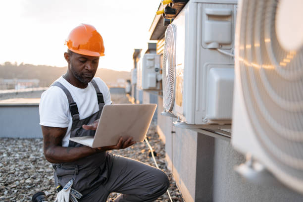 istock Carpenter using laptop while kneeling near air conditioner 1871802332