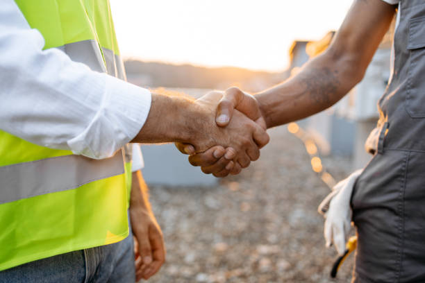 istock Roof inspectors doing hand shaking while standing outdoors 1871802360