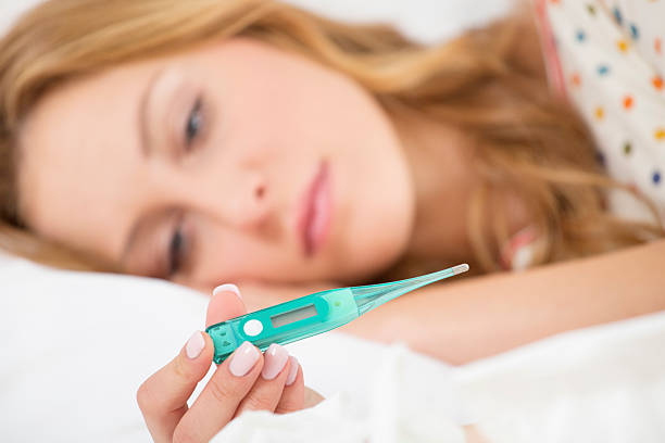 istock Sick Woman Taking Her Temperature. 187181142