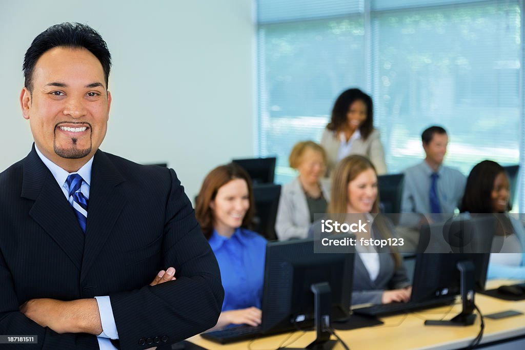 Business, Education: College instructor with computer lab students. College professor instructs his computer class, or businessman leads his team. Adult Stock Photo