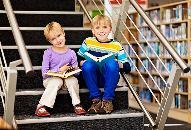 istock Happy sibling bookworms reading in library 187182516