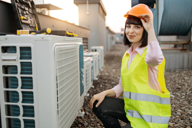 istock Woman adjusting hard hat while kneeling near air conditioner 1871835283