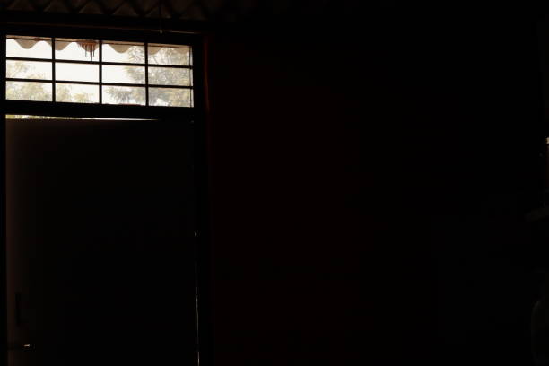 istock A dark room with small gaps in between door and a grilled window on side 1871838400