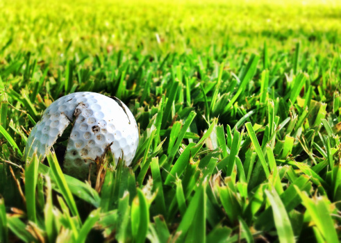 Bad day of golf - a broken golfball sits lost in the rough. This image was taken and processed with a mobile device.