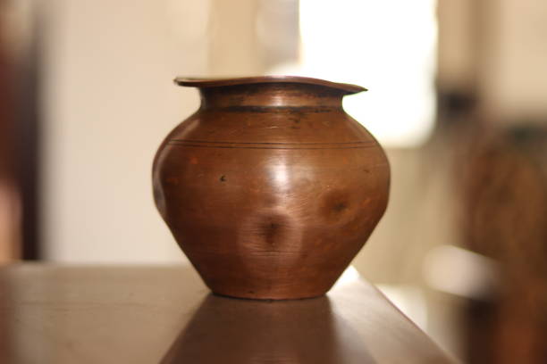 A brown colored copper vase, vessel or lota on a marble floor in selctive focus, bokeh A brown colored copper vase, vessel or lota on a marble floor in selctive focus, bokeh lota stock pictures, royalty-free photos & images