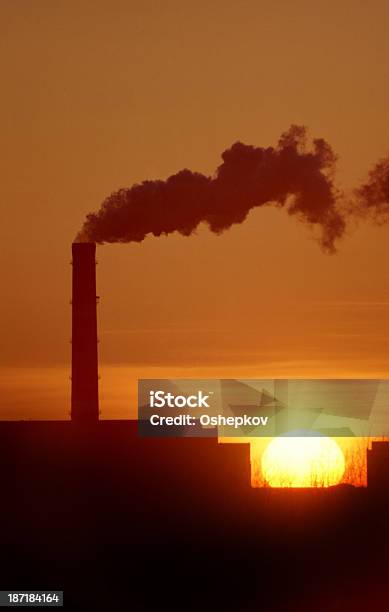 Chimneys And Smoke Against The Setting Sun Stock Photo - Download Image Now - Back Lit, City, Climate
