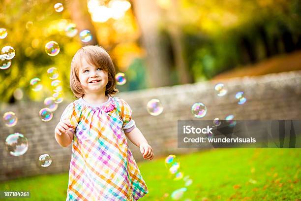 Happy Girl Standing Around Bubbles Stock Photo - Download Image Now - Bubble Wand, Baby Girls, Bubble