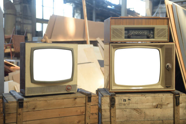 istock Two old TVs with white isolated screens in a hangar. Retro technology concept. 1871846346