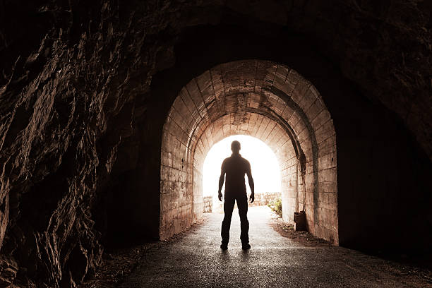 istock Young man stands in dark concrete tunnel 187184845