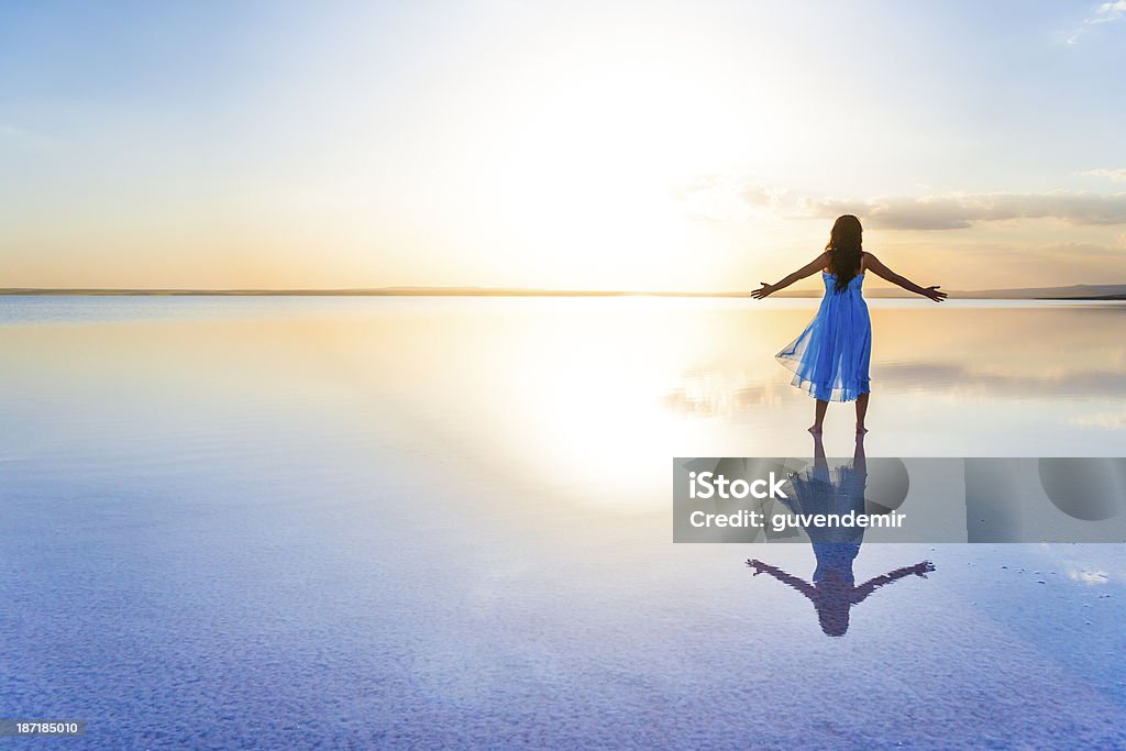 Freedom Silhouette of a woman with her arms raised to the sun Sunset Stock Photo