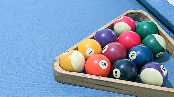 Billiard balls in a wooden box on a blue billiard table