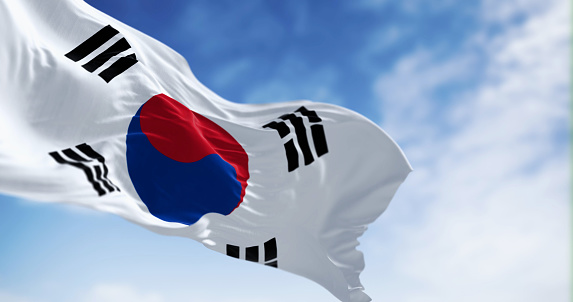 Close-up of national flag of South Korea waving on a clear day. White field, red-blue Taegeuk center, four black trigrams. 3d illustration render. Selective focus. Rippling fabric