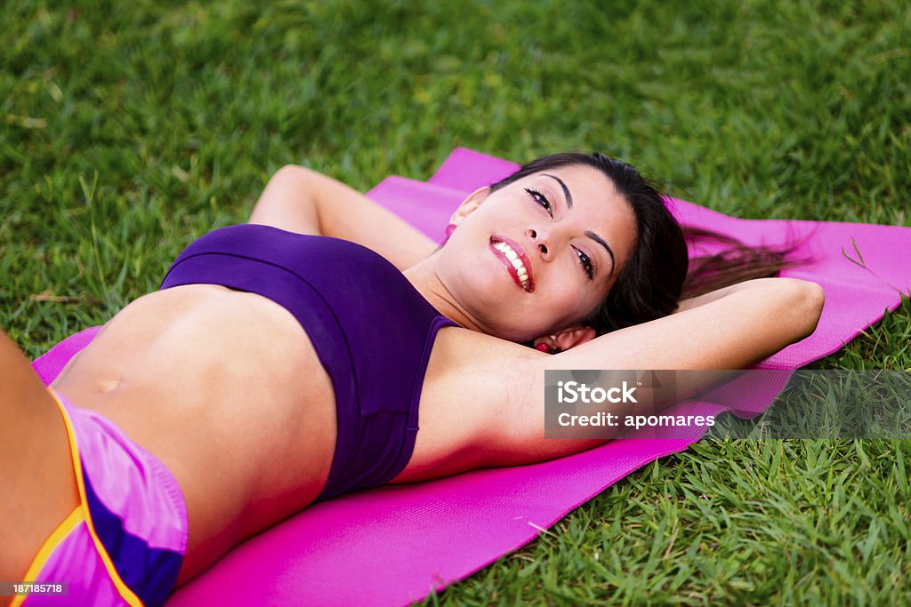 Jovem mulher relaxante enquanto fazer pilates ao ar livre na natureza - Foto de stock de 20 Anos royalty-free