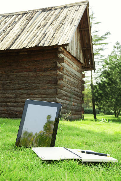 istock Leisure:digital tablet in forest with the wood house 187186206