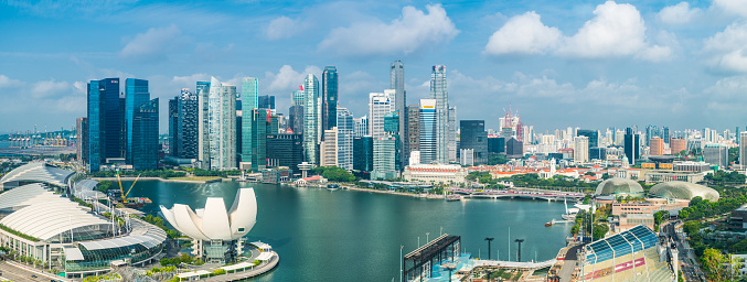 Aerial panoramic view over the towering skyscrapers of downtown Singapore surrounding Marina Bay.