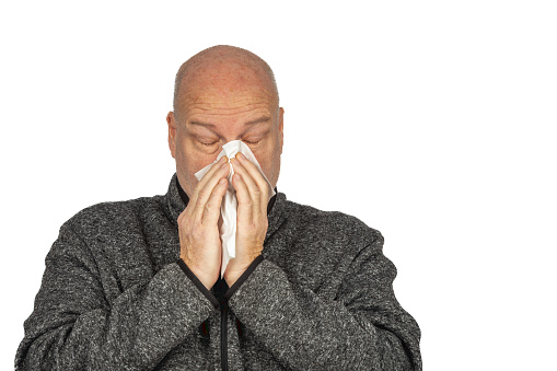 Senior Caucasian Man in Grey Sweater Jacket Sneezing with Tissue, Copy Space - Health and Illness Concept