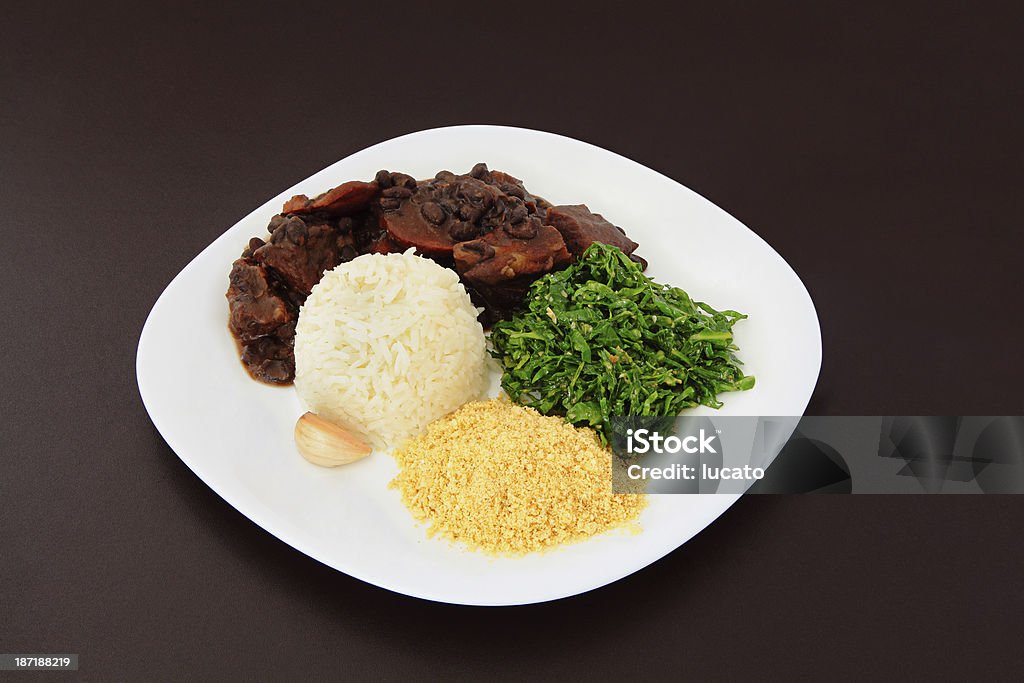Brazilian Feijoada on a plate Brazilian Feijoada on a plate on brown leather background. Feijoada Stock Photo