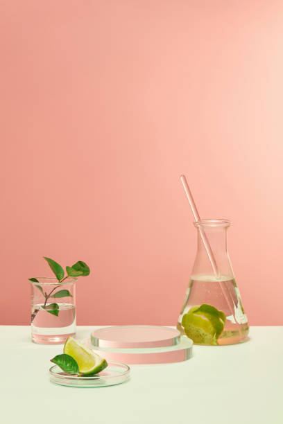 istock Glassware and fresh lemons are placed on a white table with a pink background. The space is suitable for advertising natural cosmetics. Lemon is rich in vitamin C. 1871883209